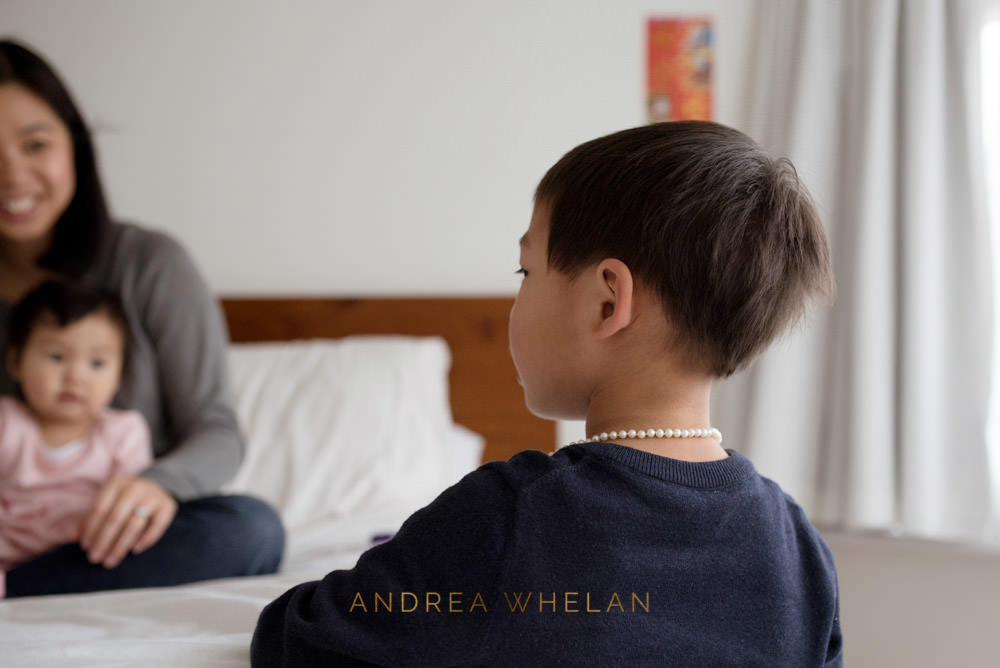 boy wearing mothers necklace